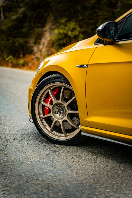 a closeup of the front wheel on a yellow sports car