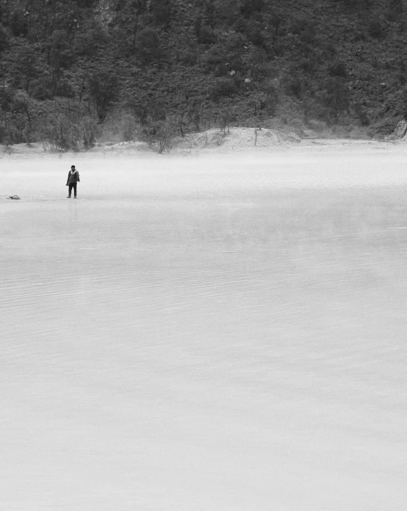 two people standing on some water in the middle of a plain