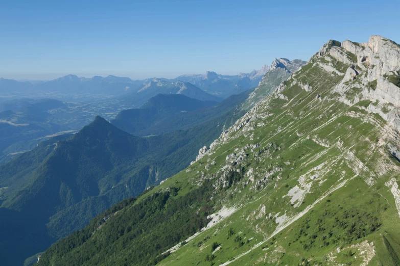 the view of a mountain with grass and trees