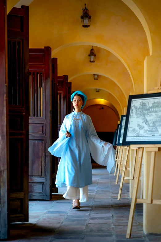 a woman standing in a room with a book and project board