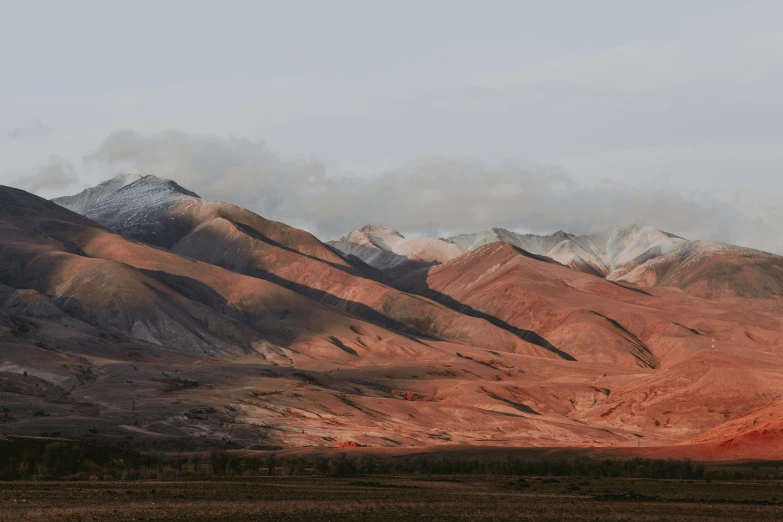 mountain scenery with orange and brown coloring with clouds