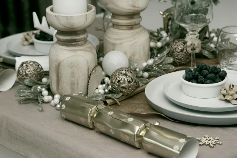 an elegant holiday table setting with candle and ornaments