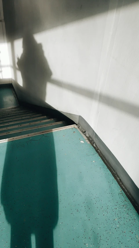 a shadow of someone's face in front of a wall