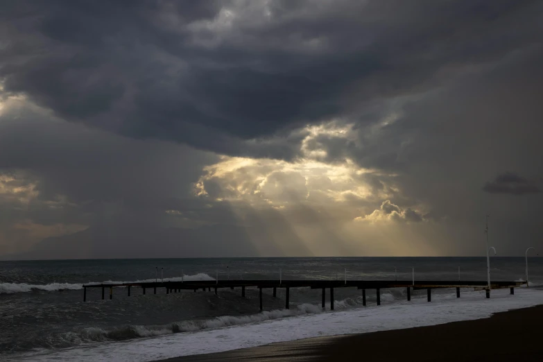 sun rays coming out of behind clouds above the ocean