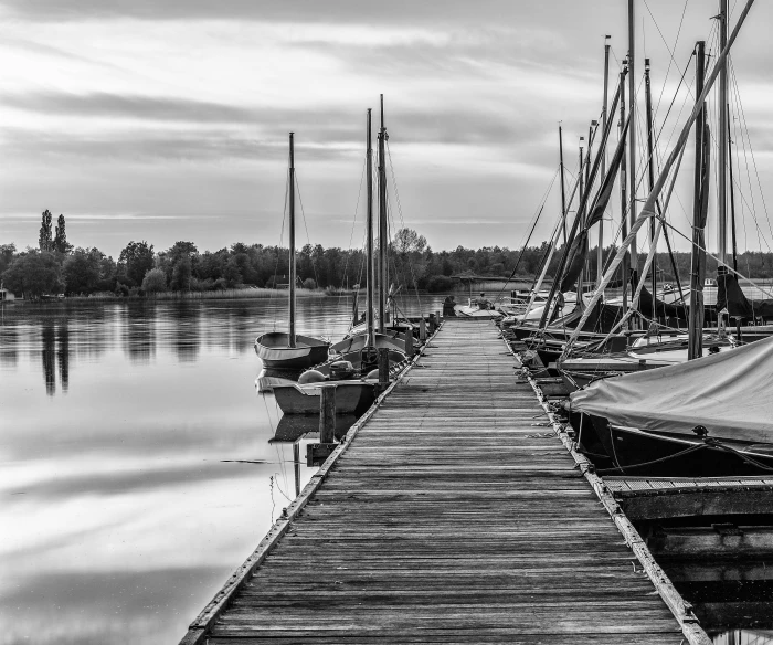 a dock is shown with sailboats and the water reflecting it