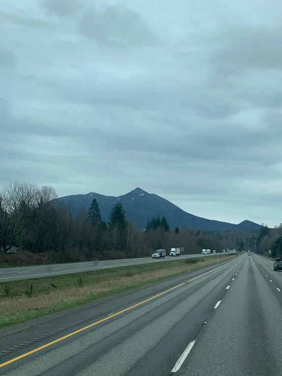 there is an empty highway in front of the mountains