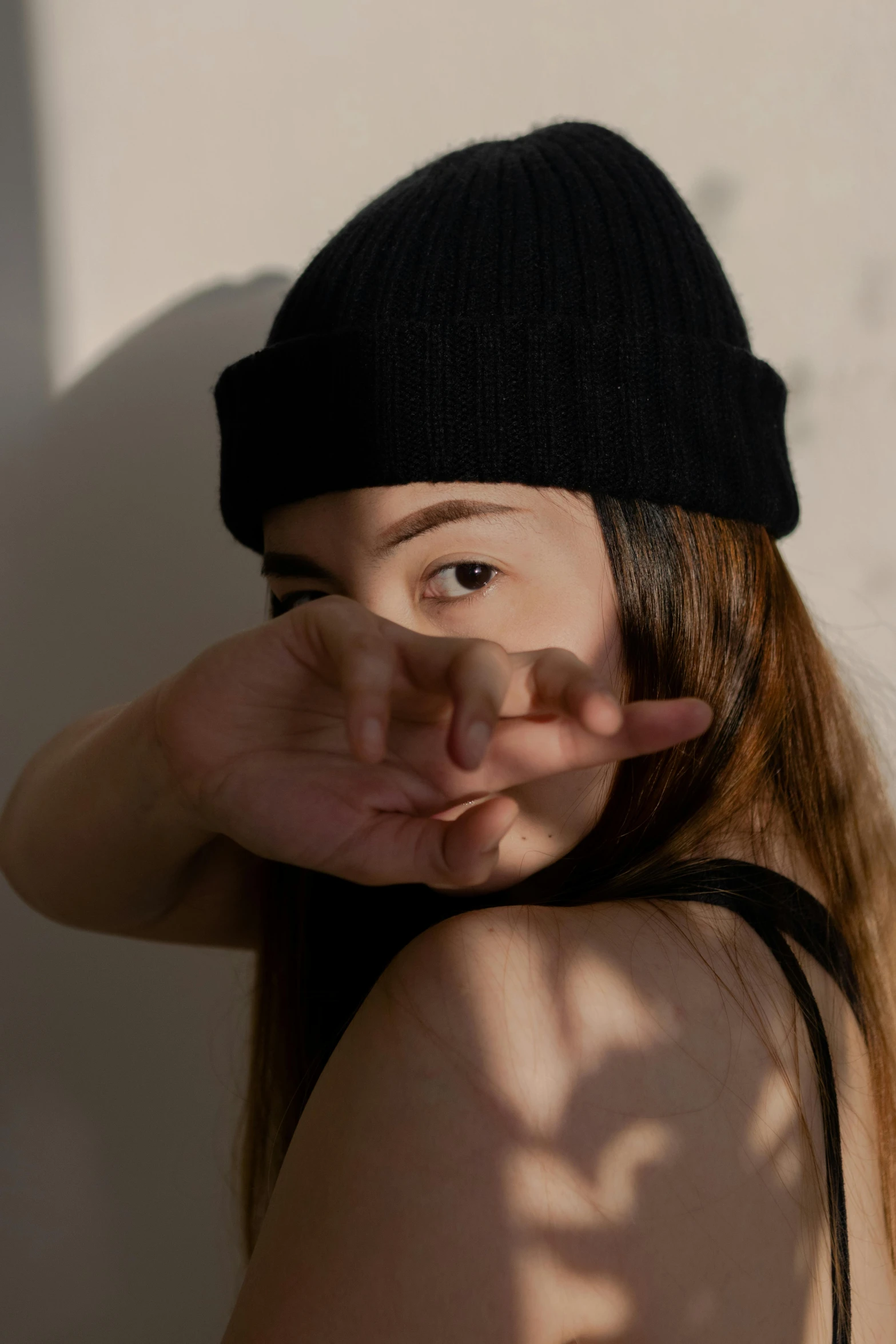 a girl in a black hat is holding her hand up with one side