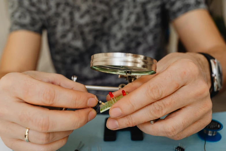 a woman is holding a small metal object in her hands