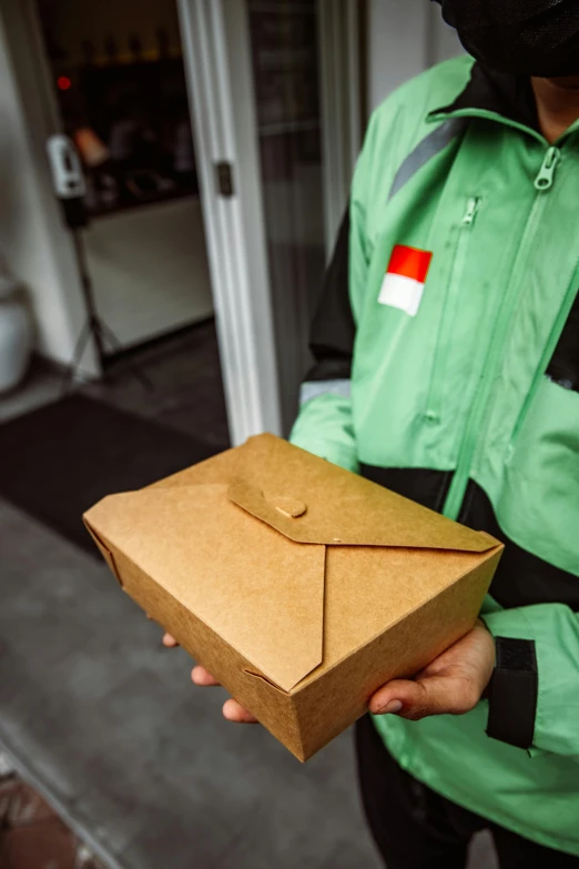a man holding a brown envelope and smiling