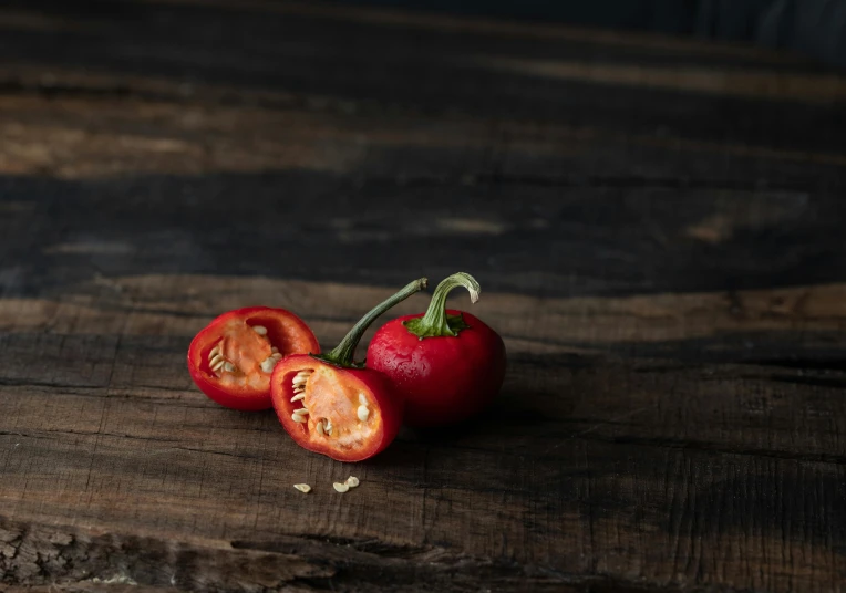 a couple of red pepper sitting on top of a wooden table