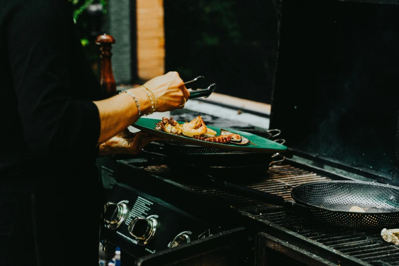 a man is cooking food on an outdoor grill