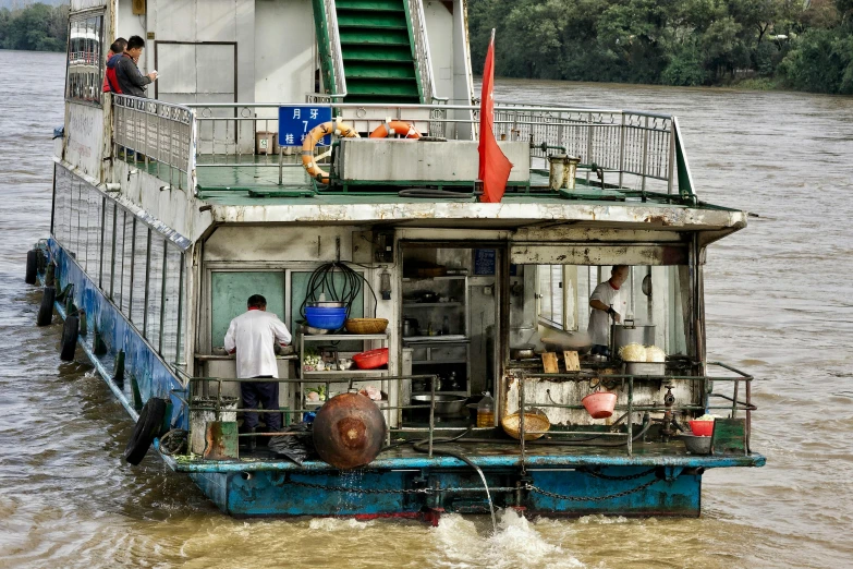 a large boat traveling down a river surrounded by green trees