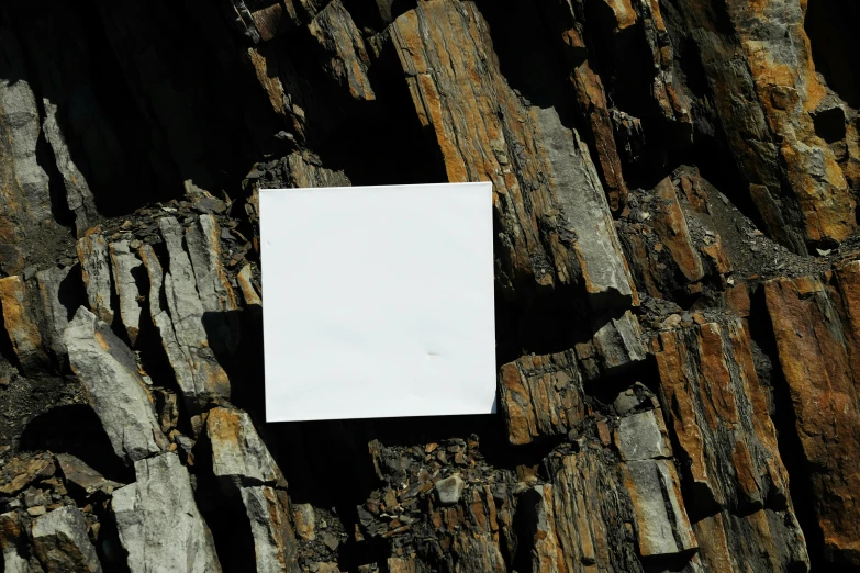 a white piece of paper is stuck to a piece of wood