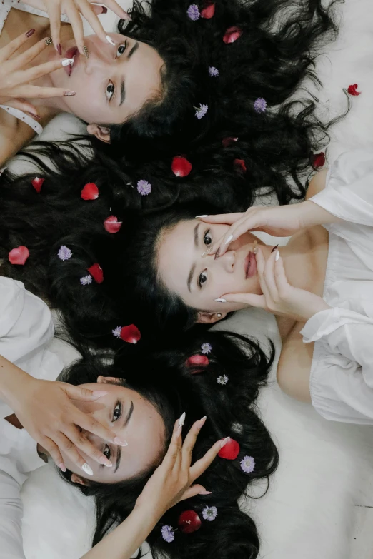 two women that are laying down with roses on their chests