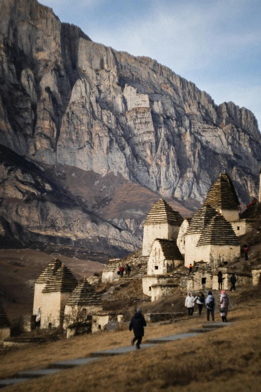 people walking down the pathway to small village