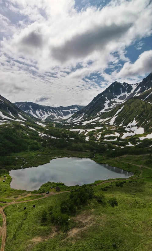 the water is surrounded by hills and snow