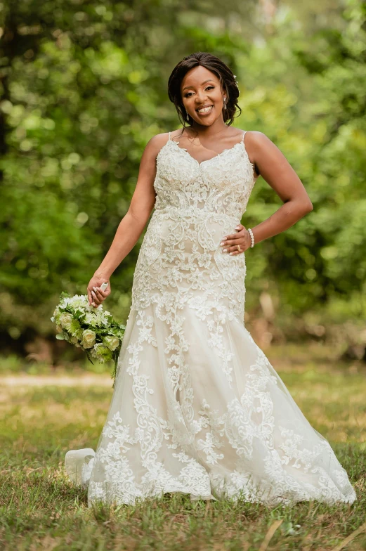 a woman posing for a wedding picture with her dress and bouquet