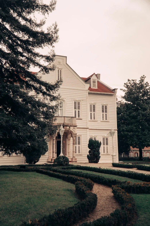 an ornate home with many windows and hedges