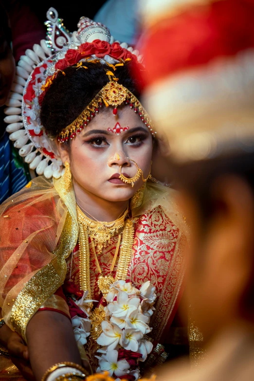 a young woman wearing gold and red in a head dress