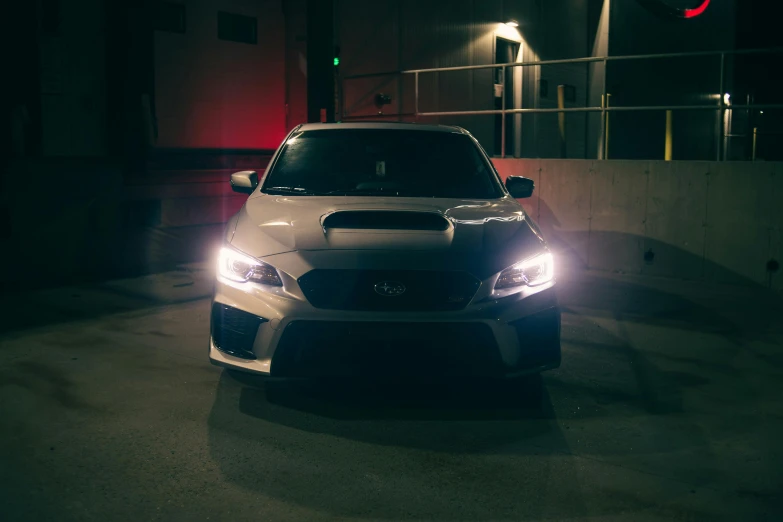 a white car is parked in the parking lot at night