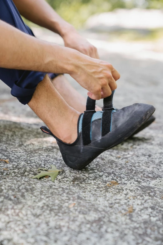 a close up of a person tying their shoes with strap