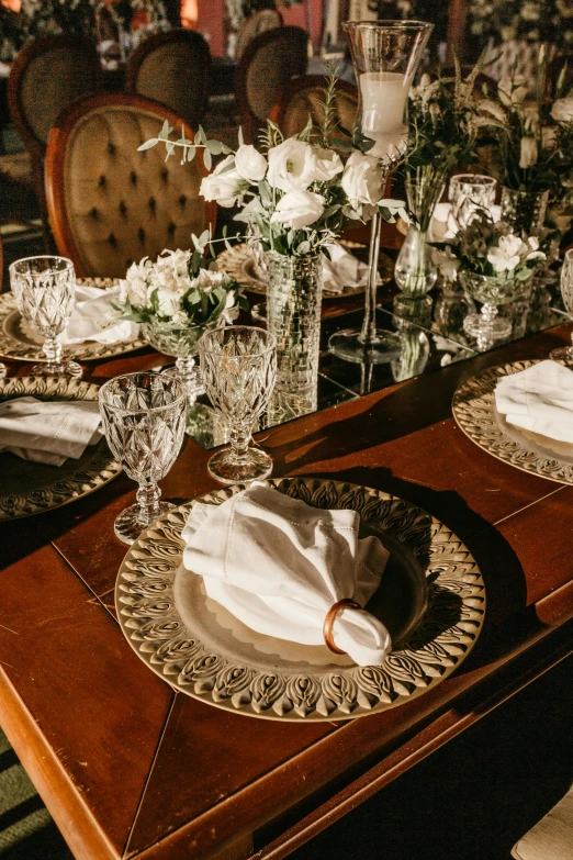 the centerpieces of a table with napkins and glassware
