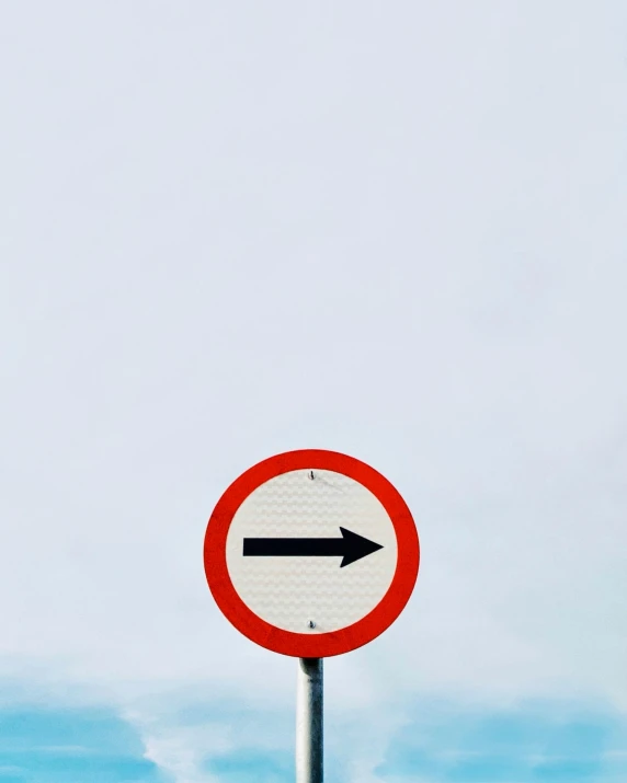 a red and white round sign pointing in opposite directions