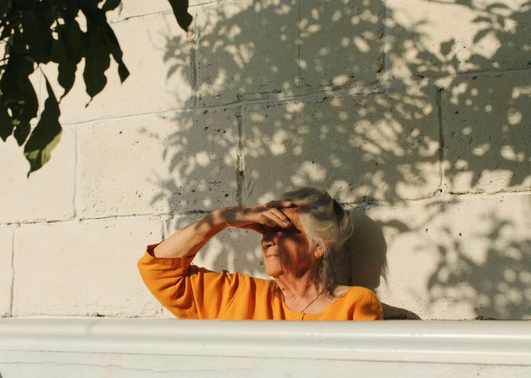 an older woman takes a picture in the sun