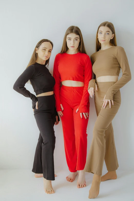 three models, two standing, one wearing crop tops and two sitting
