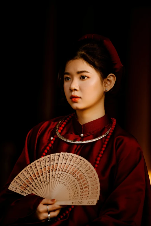 woman in traditional korean dress holding an old fan