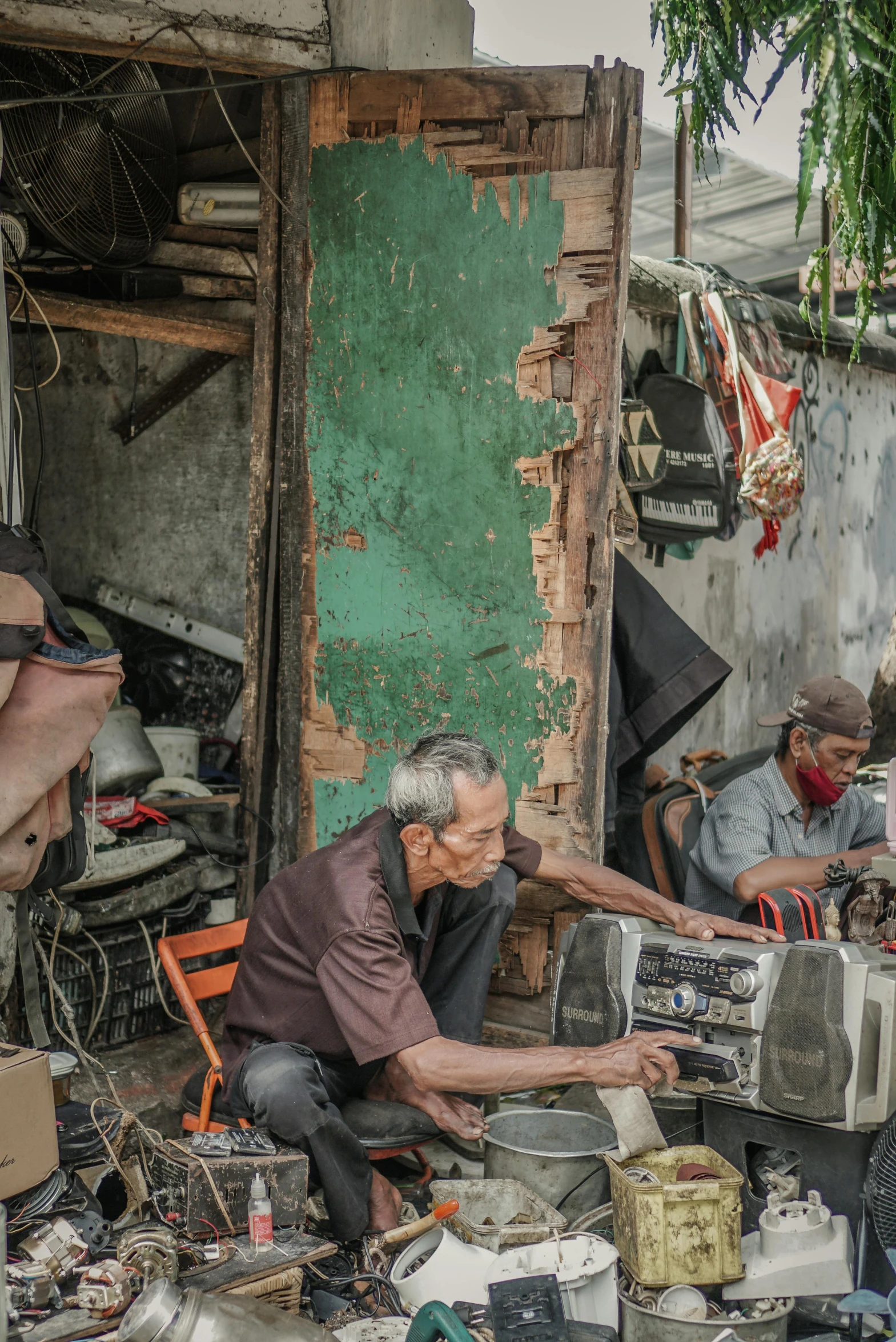 an older man has a collection of electronics in front of his home