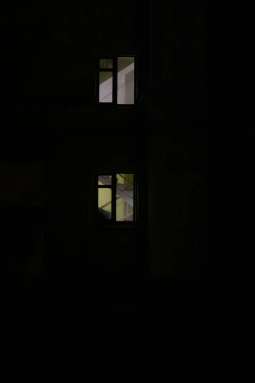 three small windows are lit in the dark