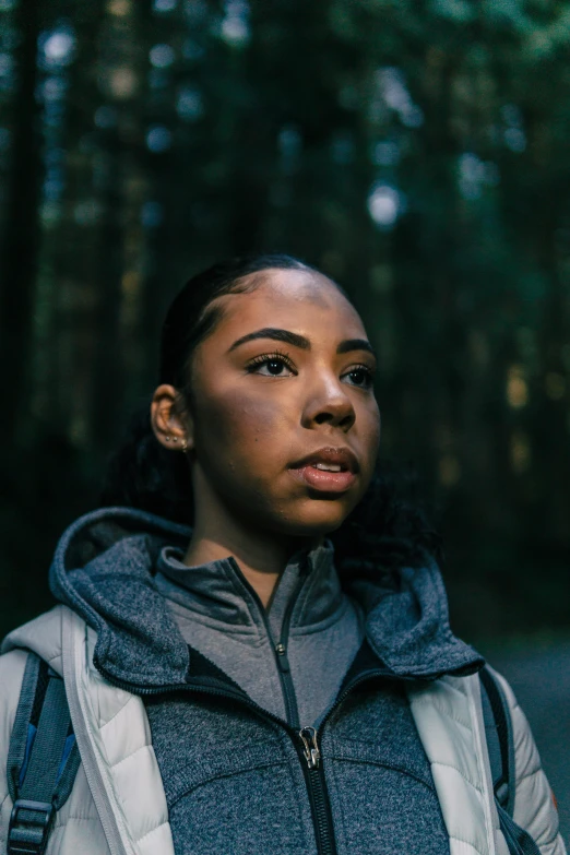 woman standing in a forest gazing straight ahead