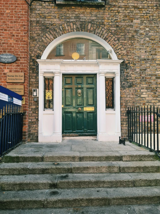 an old building is painted green and white