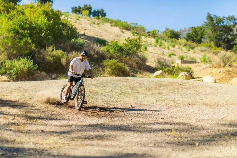 a person rides a bicycle in the grass and dirt