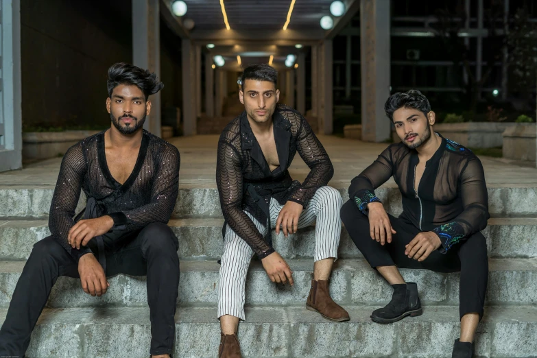 three men are sitting on the steps with one man sitting on the ledge