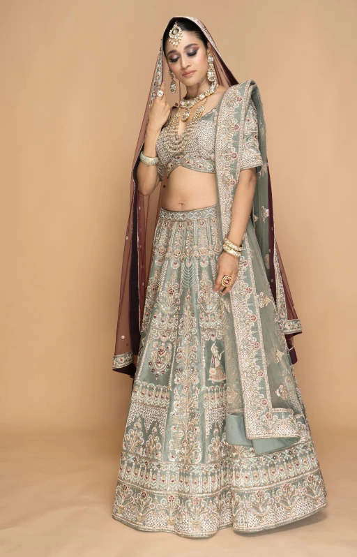 an indian bride poses in a light green lehenga