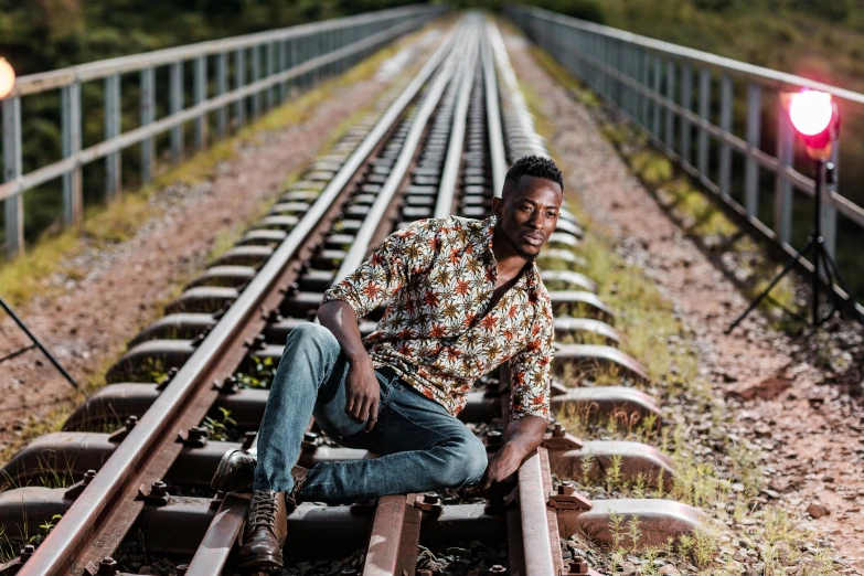 a man sits on a rail road track