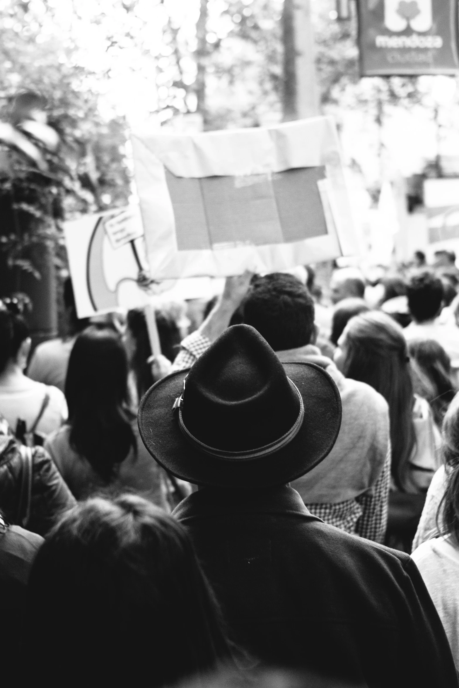 a person in a large crowd holds a sign