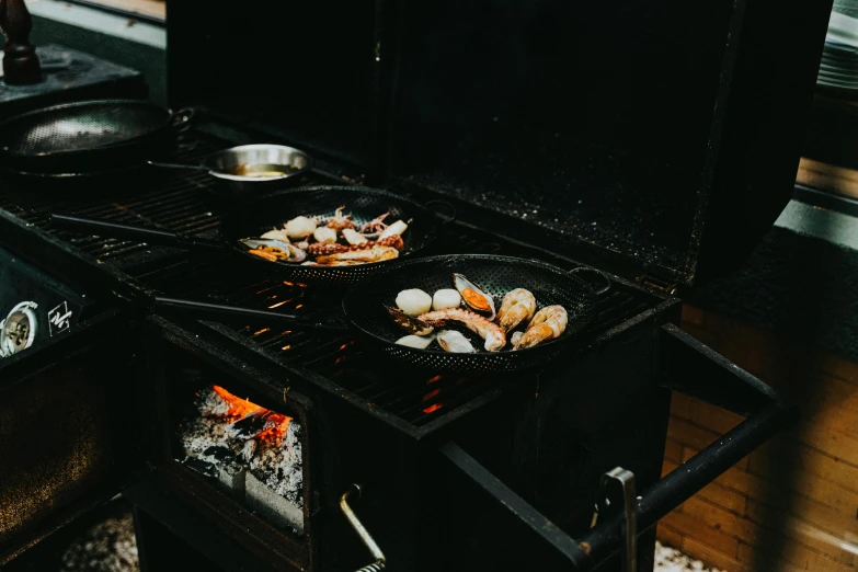 there is food cooking on an outdoor grill