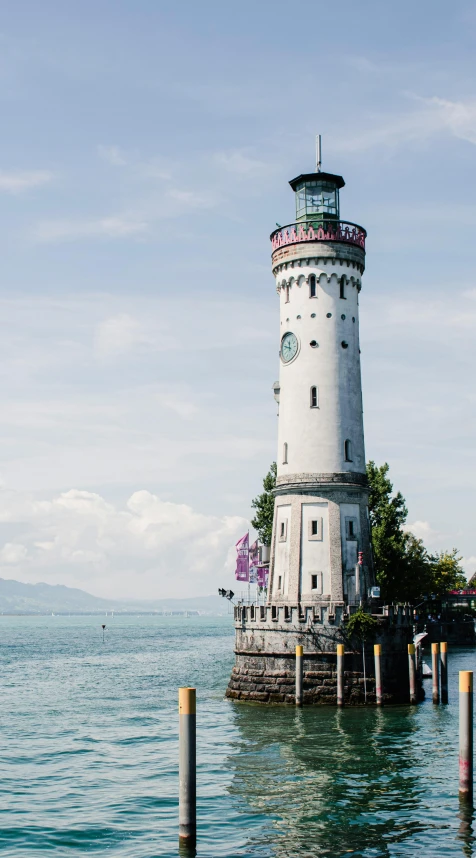 a light house is near the water under a blue sky