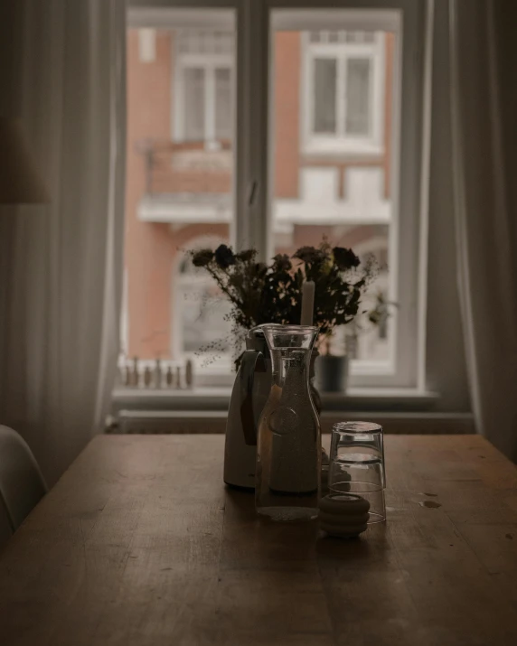 two vases with flowers in them sitting on a table