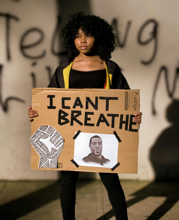a woman wearing black holding a sign with drawings