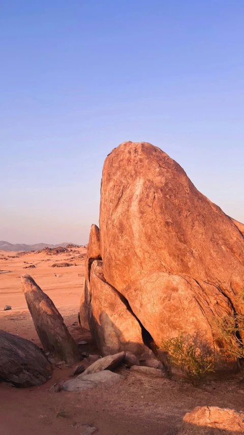 the huge rock is sitting alone in the middle of the desert