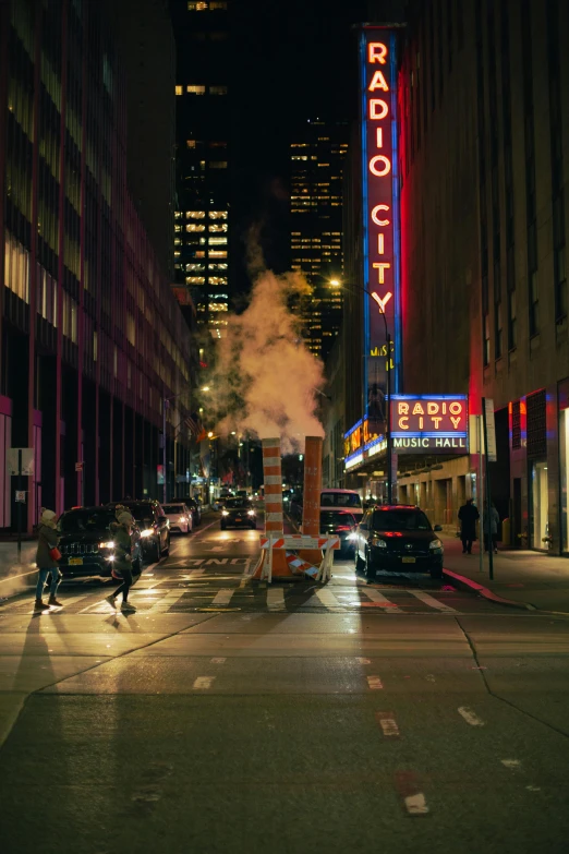 a city street scene at night with cars and people