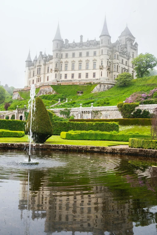 an ornate castle sitting in the middle of a lush green landscape