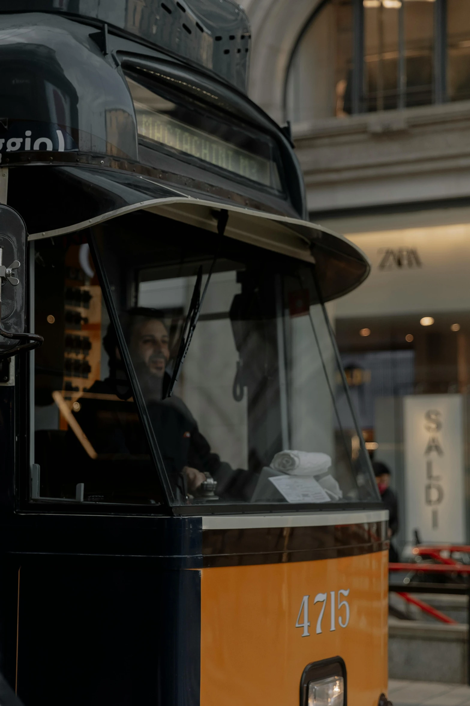 a man driving a bus down the street