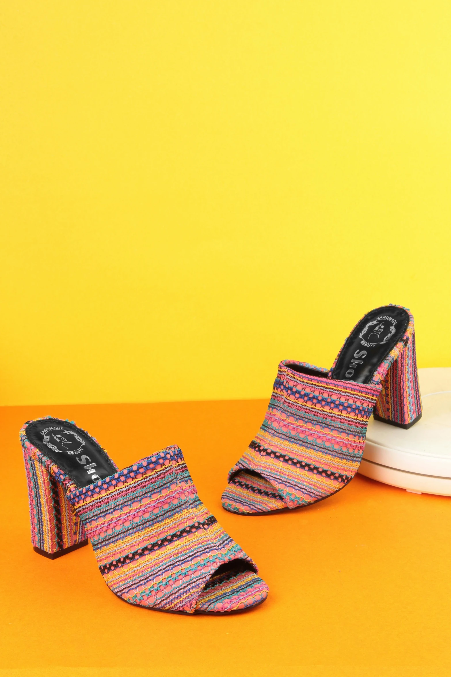 a pair of colorful sandals sitting on top of an orange surface