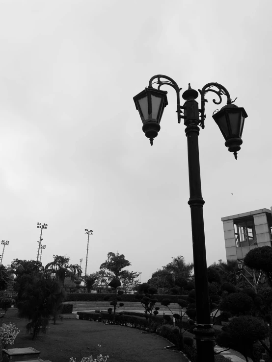 a clock tower in the distance with two street lamps near by