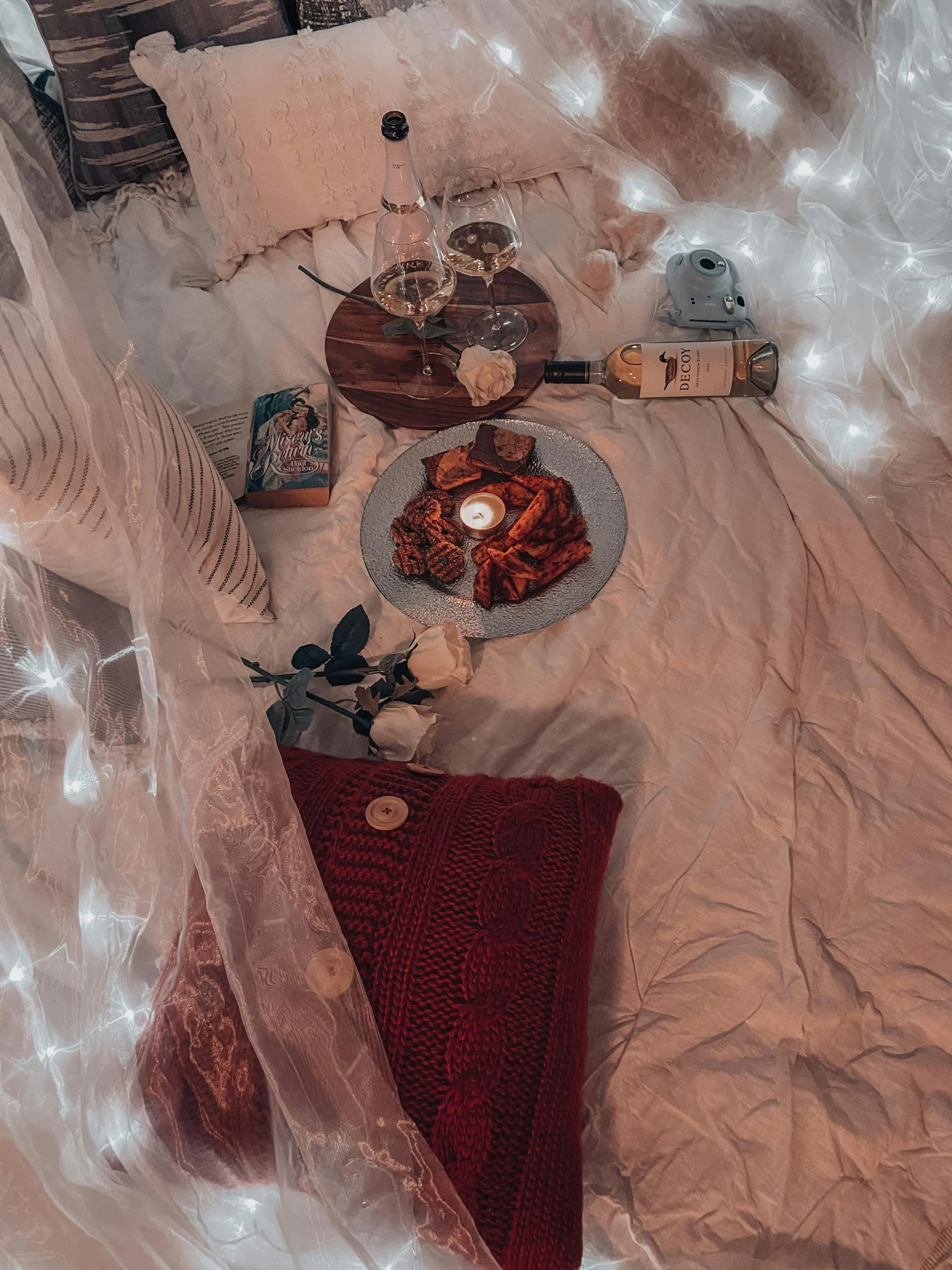 a table topped with cakes and cupcakes on top of a bed